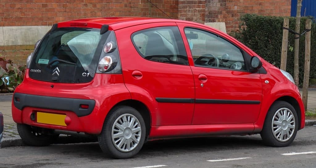 A red car parked on the side of the road.