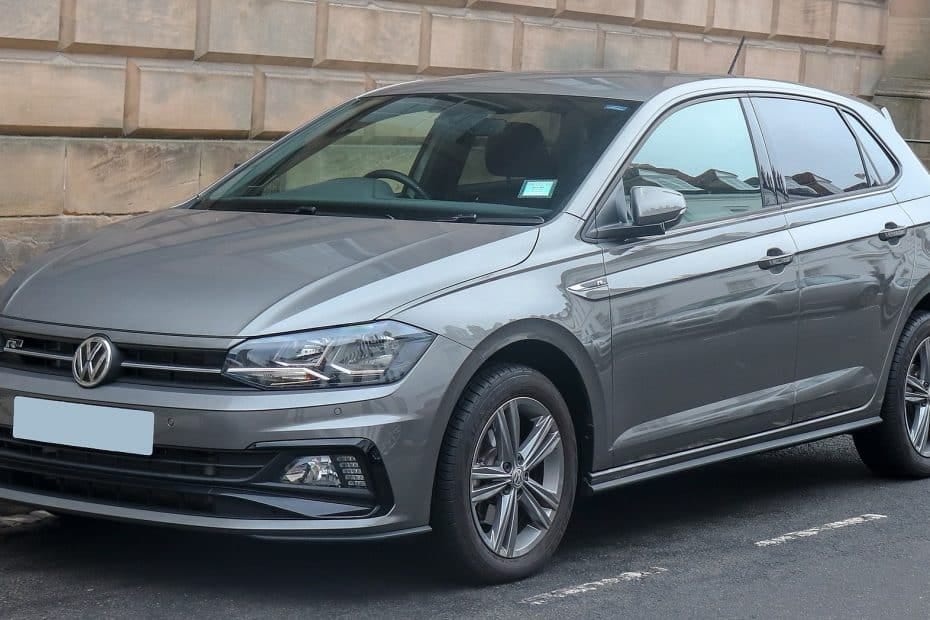 A grey volkswagen polo parked on the side of a street.
