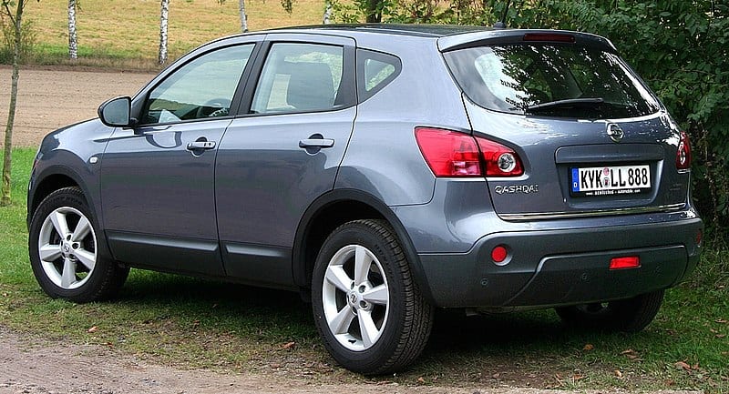 A gray suv parked on a dirt road.