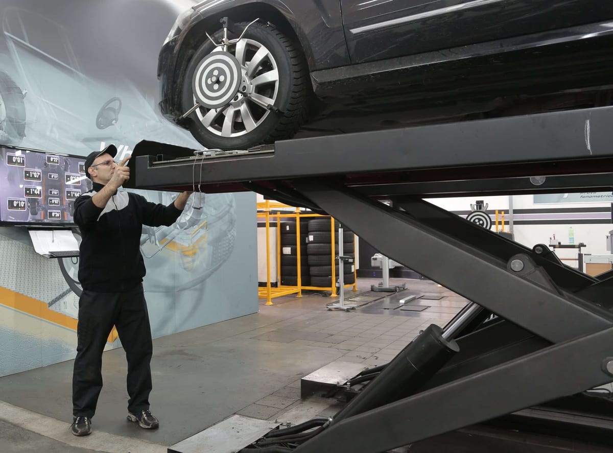 A man working on a car on a lift.