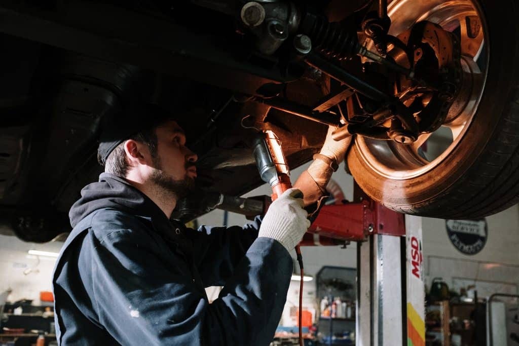 A mechanic working on a car in a garage.