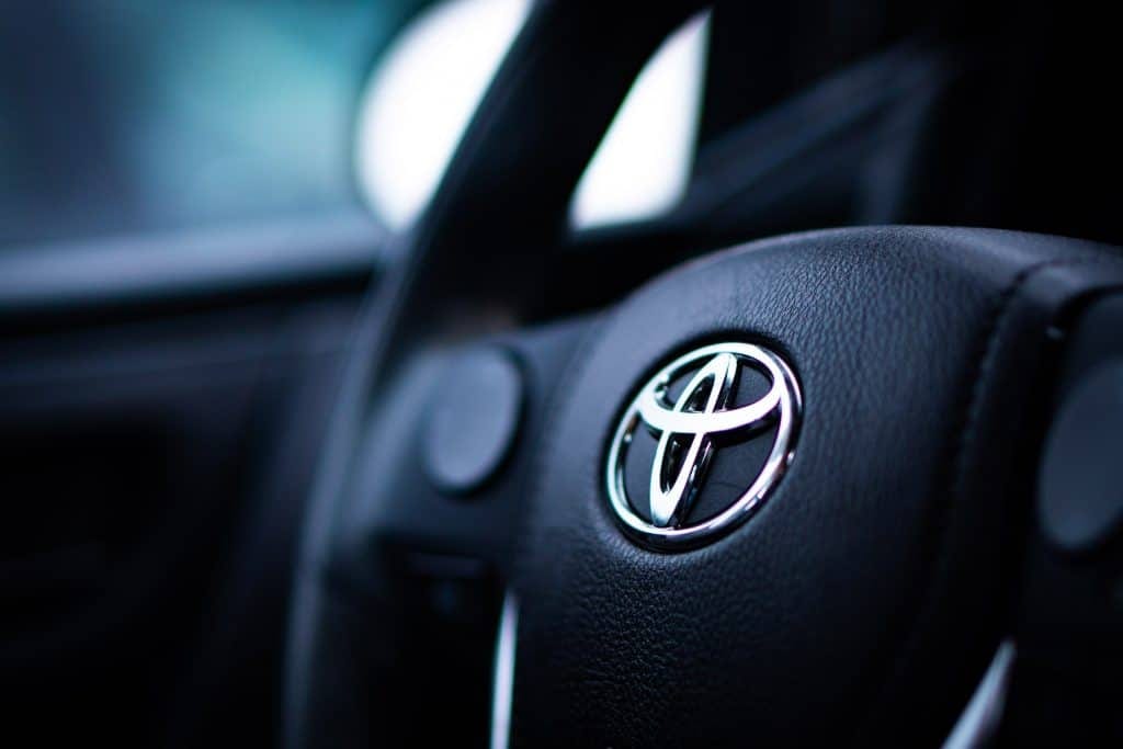 A close up of the steering wheel of a toyota car.