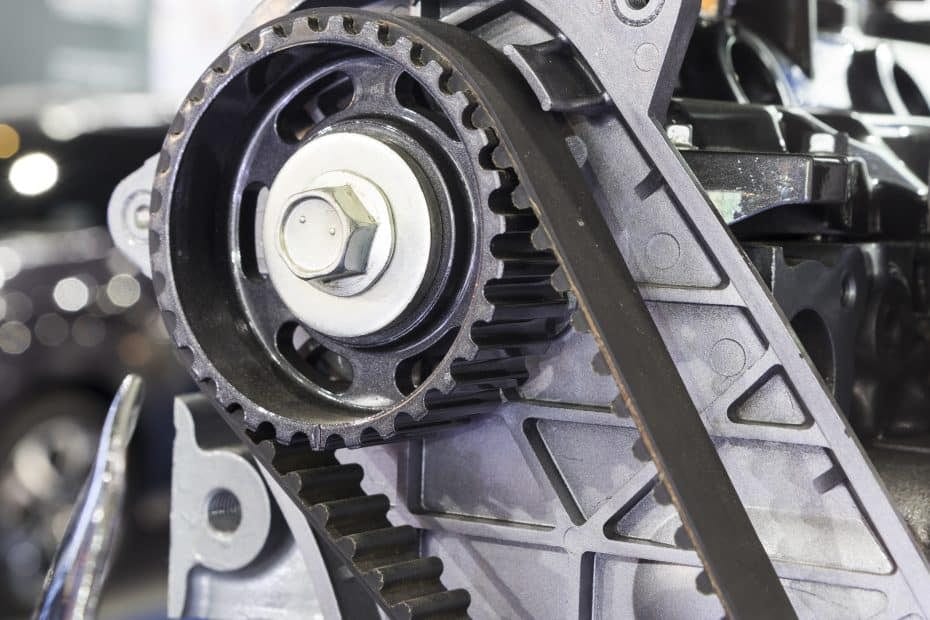 A close up of a car engine with a belt.