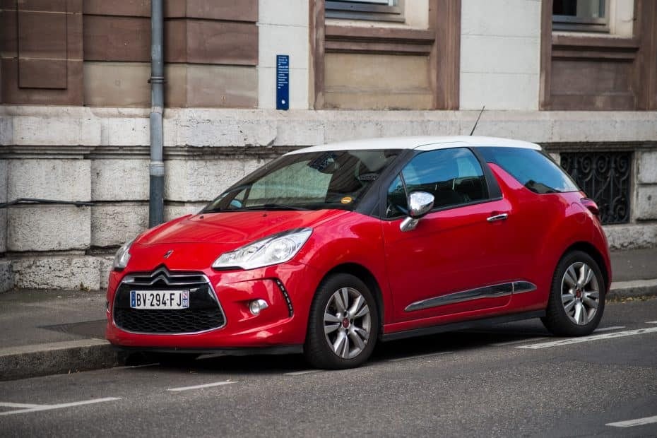 A red citroen c3 parked on the side of a street.