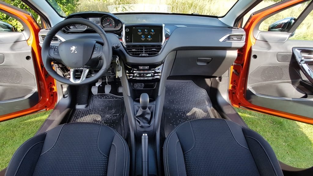 The interior of a car with orange seats and a steering wheel.