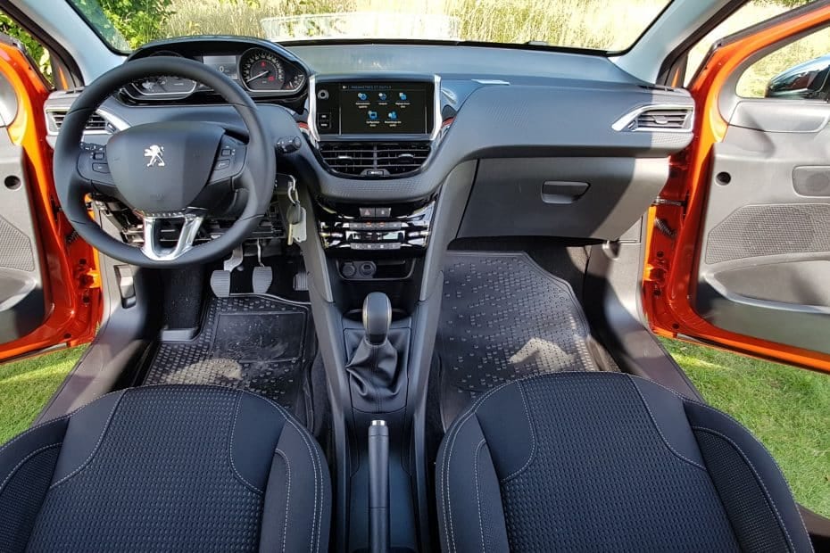 The interior of a car with orange seats and a steering wheel.