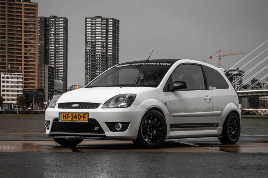 A white ford fiesta parked in front of a building.