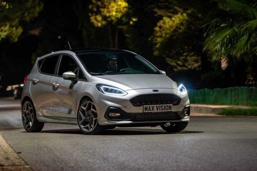The 2019 ford fiesta st is driving down a street at night.