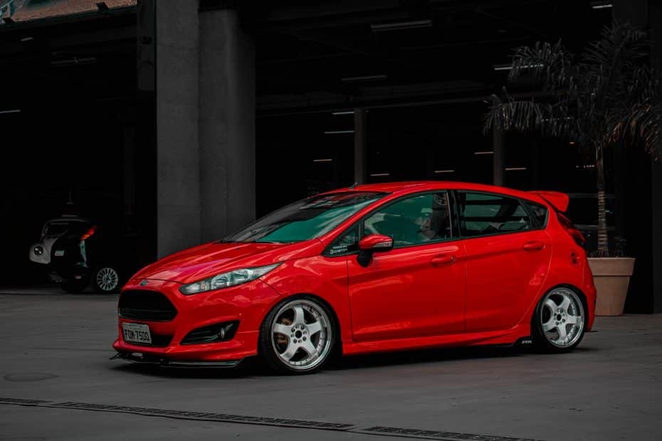A red ford fiesta parked in front of a building.
