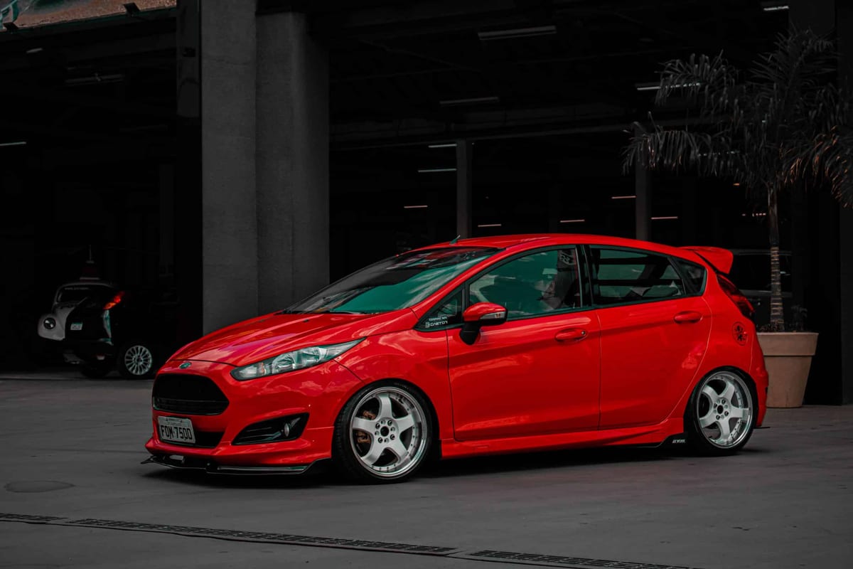 A red ford fiesta parked in front of a building.