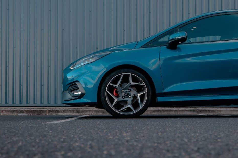 A blue ford fiesta st parked in front of a building.