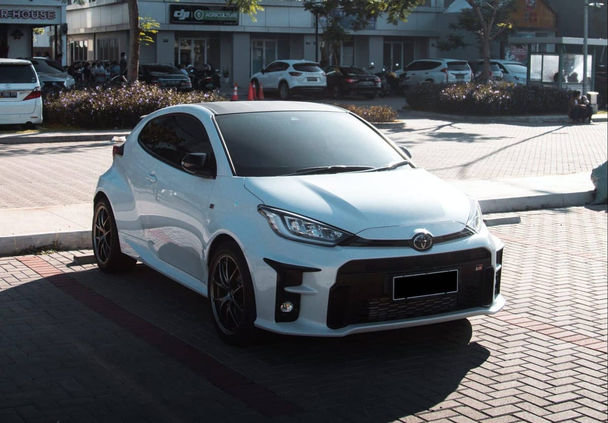A white toyota yaris parked on a street.